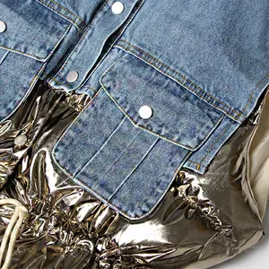 Detailopname van patchwork denim vest met glanzende metallic stof en trekkoord detail.