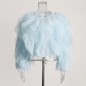 Detailansicht der hellblauen Rüschenbluse mit langen Ärmeln auf transparentem Torso.