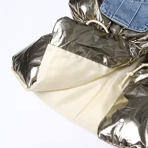 Detailopname van metallic bronzen puffer materiaal met blauwe denim patchwork en beige voering