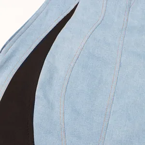 Detalle en primer plano del vestido vaquero azul claro con tela negra y costuras