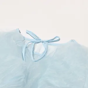 Nahaufnahme des hellblauen Rüschentops mit elegantem Schleifenausschnitt und Textur.