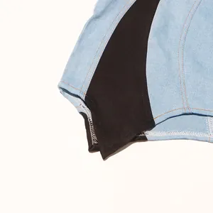 Primer plano de un vestido vaquero bicolor con costuras en contraste y dobladillo.