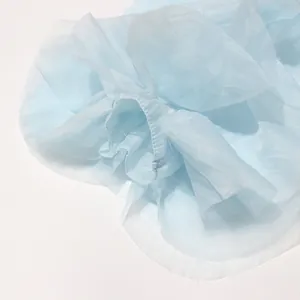 Detaillierte Nahaufnahme der hellblauen, transparenten Rüschenstoffstruktur und Näharbeit