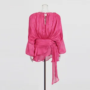 Back view of elegant fuchsia pleated mini dress featuring a waist tie and long tassels