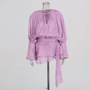 Detailed view of a lilac high-waist mini dress featuring elegant pleated long sleeves.
