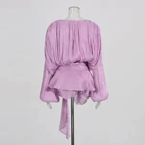 Back view of purple pleated mini dress featuring lantern sleeves and waist tie