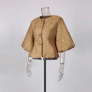Close-up of golden French style tweed jacket with puff sleeves and round neckline