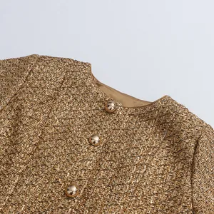 Detailed view of elegant gold sequin tweed jacket featuring round neck and metallic buttons