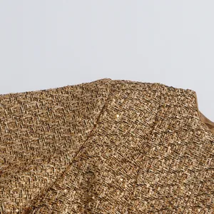 Close-up view of premium gold tweed fabric and sequin details on a French round neck jacket