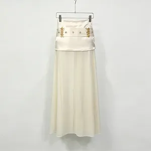 Detail view of cream sheer gauze skirt with gold wheat pattern waist accessory
