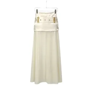 Detailed view of white sheer gauze midi skirt featuring golden leaf belt accents