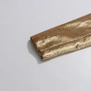 Macro detail of high-density gold sequined sleeve on a luxury women's fashion blazer