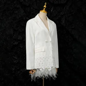 High-end white blazer detail featuring luxury ostrich feathers and shell patchwork.