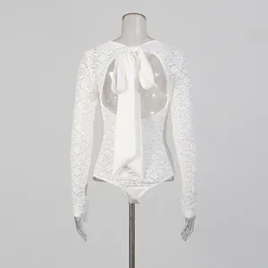 Detailed back view of a white floral lace long sleeve bodysuit with a large satin bow tie