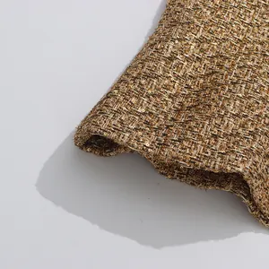 Detailed close-up view of premium gold tweed fabric with shimmering sequins for a jacket