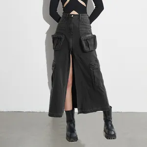 Detail of high-waisted black denim cargo maxi skirt with front slit and large pockets.