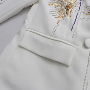Close-up of white blazer with fireworks gold sequin embroidery and flap pocket detail