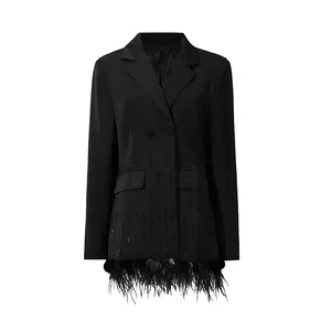Detailed view of women's black blazer with ostrich feather and shell patchwork hem
