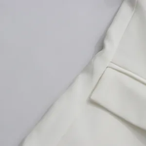 Macro view of high-quality white blazer fabric showing fine texture and clean stitching