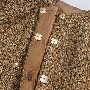 Close-up of golden sequined tweed jacket with gold snap buttons and satin lining