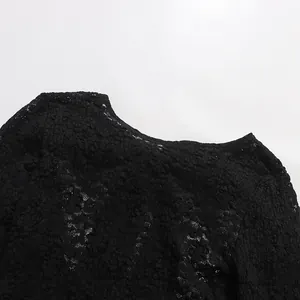 Detailed macro view of black floral lace fabric texture on a sheer feminine bodysuit