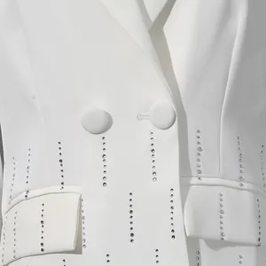 Close-up of a white blazer featuring vertical lines of sparkling rhinestone embellishments