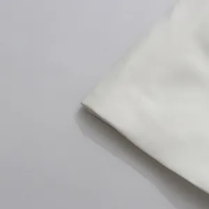 Macro detail of white textured fabric showing fine weave for elegant blazer garment