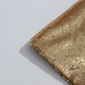 Detailed close-up shot showing high-quality gold sequins on a luxury suit jacket fabric
