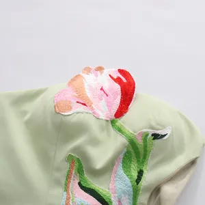 Detailopname van het bloemenborduurwerk op een Franse retro mintgroene strapless jurk