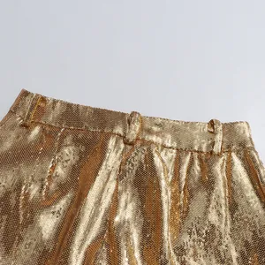 Close-up view showing the shimmering gold sequin texture on the trousers waistband