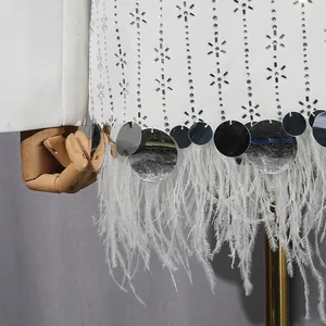 Close-up detail of white blazer with luxury ostrich feather trim and silver sequins.