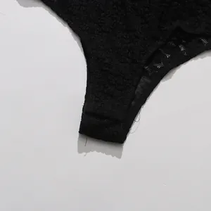 Detailed close-up view of intricate black floral lace on a sexy women's bodysuit.