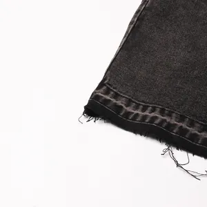 Close-up detail of high waist denim skirt featuring raw edge hem and faded grid pattern