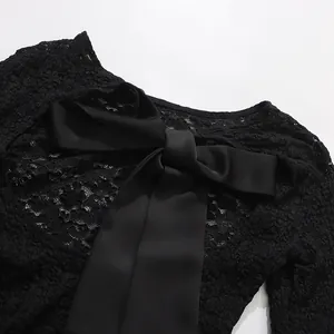 Detailed macro view of black lace bodysuit featuring elegant satin bow tie back design