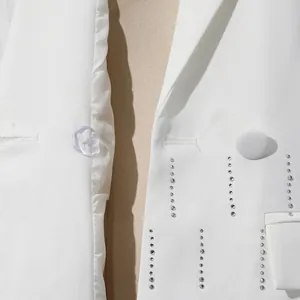 Macro view of white tailored blazer showing vertical lines of sparkling rhinestones