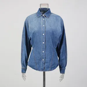 Front view detail of a retro blue denim shirt with cinched waist and button-down front.