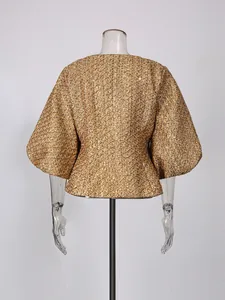 Back view of a luxury golden tweed jacket with puff sleeves and peplum waist