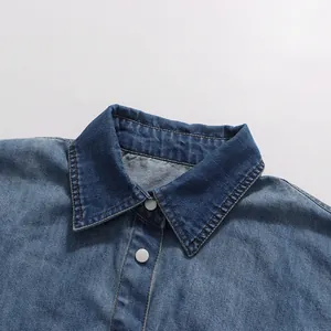 Close-up of retro blue denim shirt collar with silver buttons for elegant summer set.