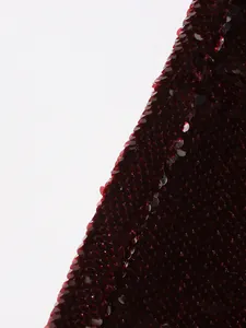 Detailed macro shot of shimmering wine red round sequins on high-end fashion blazer fabric