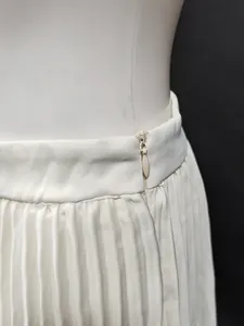 Vue détaillée d'une jupe longue plissée blanche à taille haute avec fermeture invisible