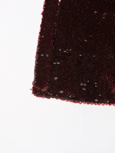 Macro view showing the intricate texture of burgundy sequins on a high-end blazer