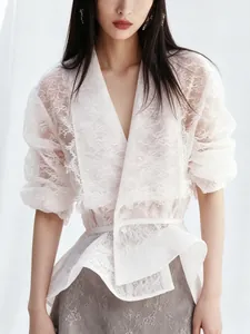 Detailansicht elegante weiße Spitzenbluse mit französischen Rüschen und Bindegürtel