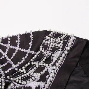 Detailed macro view of a luxury palace style blazer with white printing and pearl beads.
