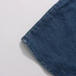 Close-up detail of a vintage blue denim skirt hem showing fine stitching and fabric texture