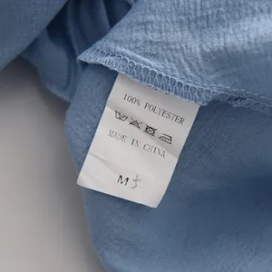 Close-up view of the care label and 100% polyester fabric texture for the light blue set