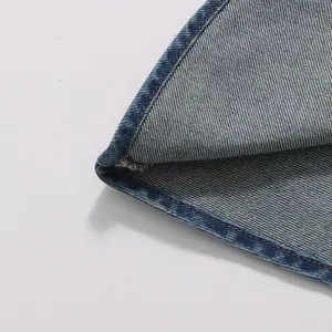 Macro view of blue denim fabric showing detailed stitching and twill weave texture