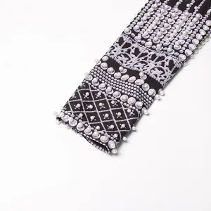 Detail view of palace style printed blazer sleeve with heavy pearl bead embellishments