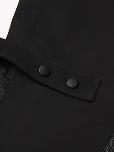 Detailopname van een zwart mouwloos vest met lederen patchwork en matte knopen