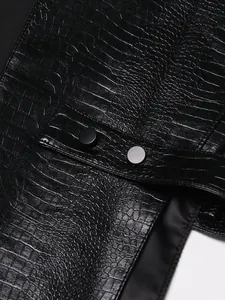 Close-up van zwart kunstleren vest met krokodillenreliëf en matte knoopdetails