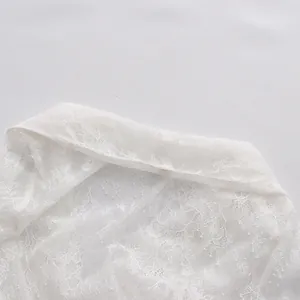 Detailaufnahme von weißem Spitzenstoff und Kragen einer französischen Bluse.